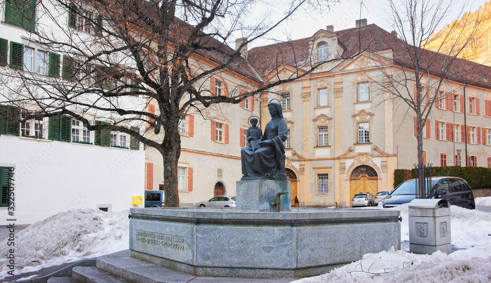 Fototapeta premium Monument near Cathedral of the Assumption in Chur at sunrise