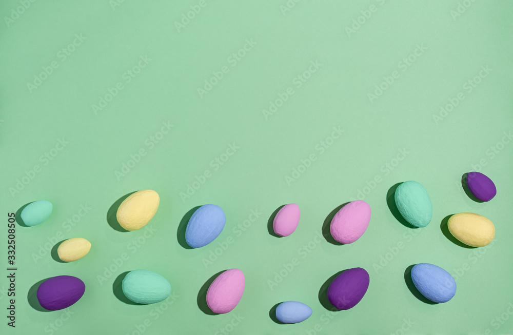 Easter eggs colored with hard shadows on a green background, copy space, flat lay. Easter eggs colored with hard shadows on a green background, copy space, flat lay.