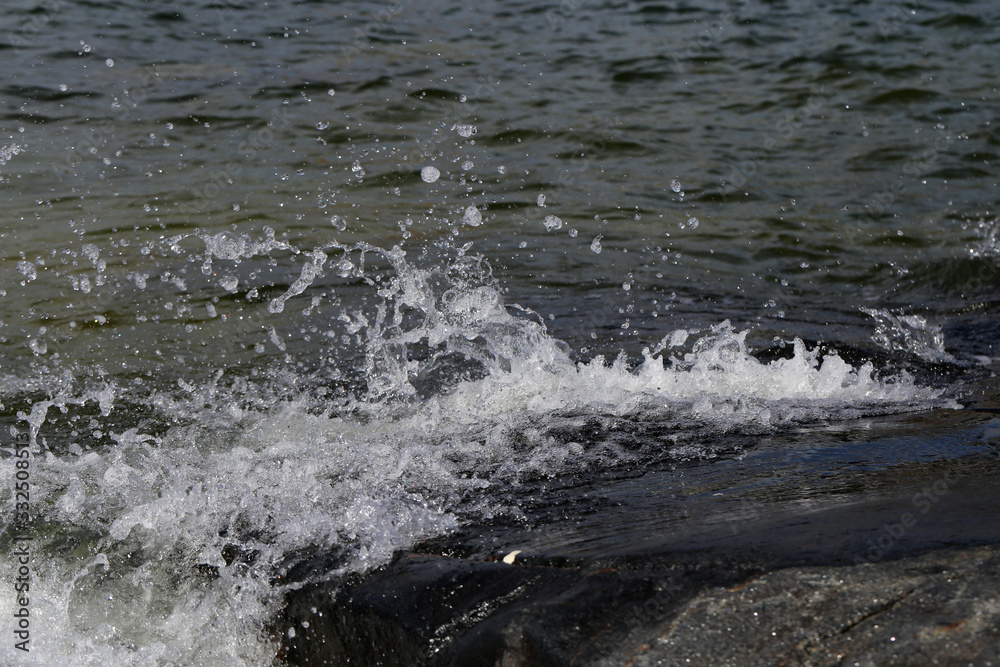 Waves hitting rocks in Helsinki, Finland. Beautiful photo representing the power and strength of the sea during windy weather. Waves can be dangerous but they also create beautiful splashes. Waves hitting rocks in Helsinki, Finland. Beautiful photo representing the power and strength of the sea during windy weather. Waves can be dangerous but they also create beautiful splashes.
