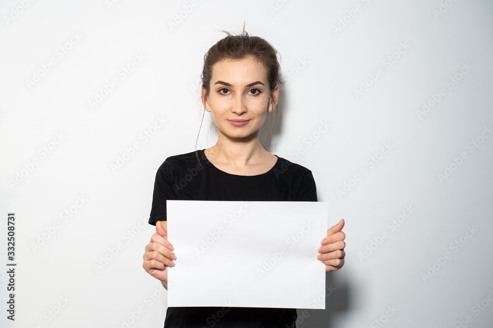 Girl holding a white paper in hands Girl holding a white paper in hands