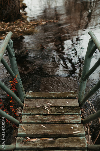 From above small pier of ancient shabby wooden stairs to flowing river in autumn day in United Kingdom photo