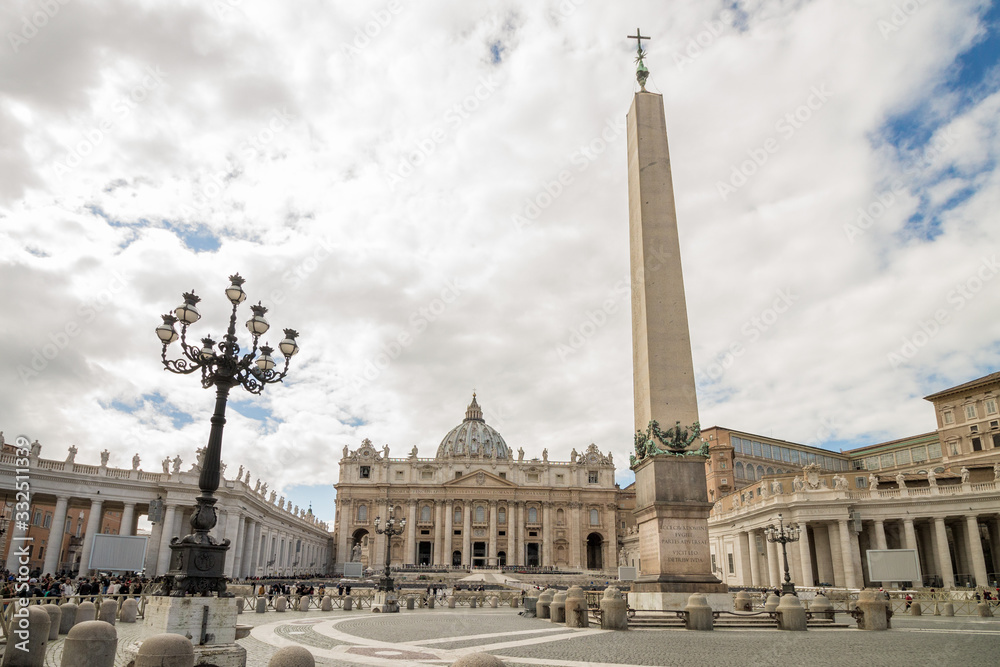 St Peter´s square in Vatican City with obelisk, street lamp and St Peter Basilica on a cloudy day, Rome, Italy. Top view.