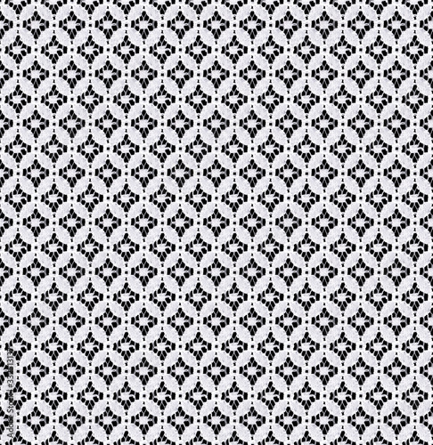 Seamless pattern in the form of a delicate white lace on a black background. Lace with geometric motifs.Material for stylish graphic decoration.