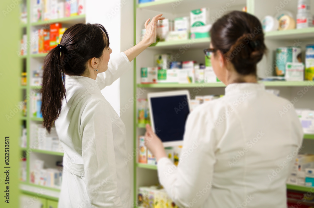 Pharmacist filling shelves with medicines 