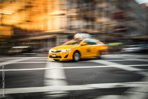 Gelbes Taxi in Ney York auf einer Kreuzung in Bewegung.