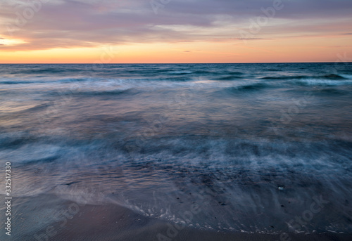 Wellengang am Meer in Dänemark. Strand im Sonnenuntergang.