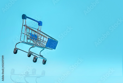 Shopping Cart flies on a blue background.The concept of the medicine of online shopping. Copy space for text