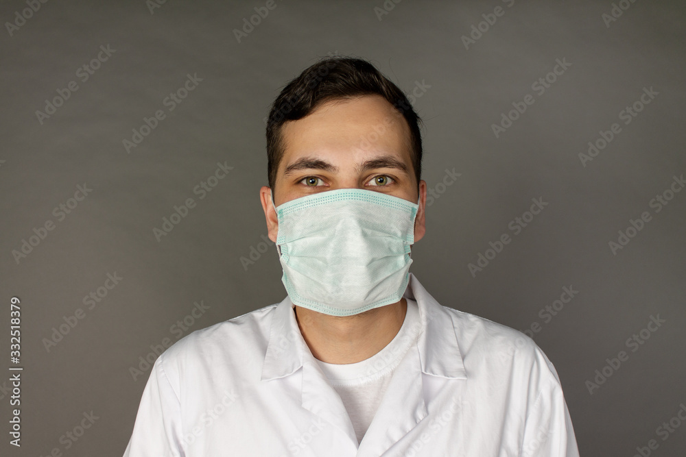 Portrait of a doctor in a medical gown and protective mask.