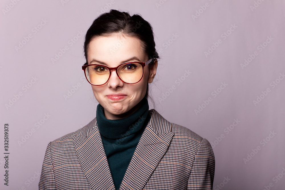 girl in a green turtleneck, jacket, glasses, portrait on a gray background