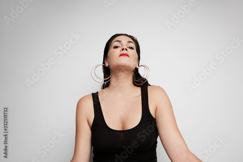 Portrait of woman with dark and wet hair posing on the white background. Horizontal.