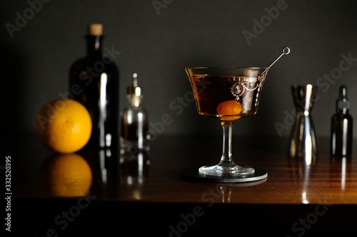 Manhattan red delitious cocktail with orange on dark background photo