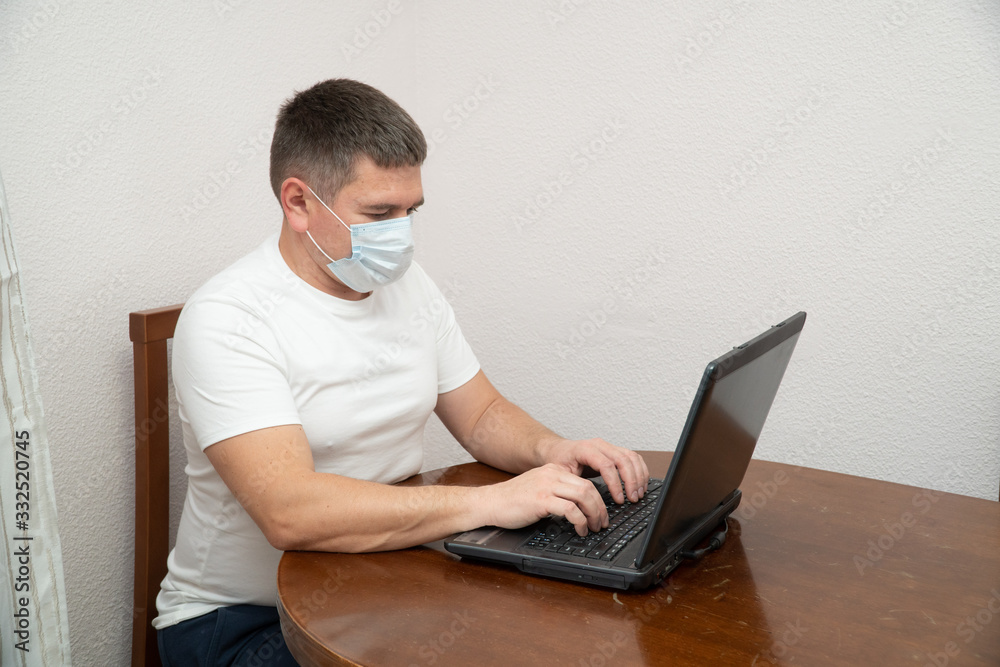 Coronavirus. Business man working from home wearing protective mask. Business man in quarantine for coronavirus COVID-19 wearing protective mask. Working from home.