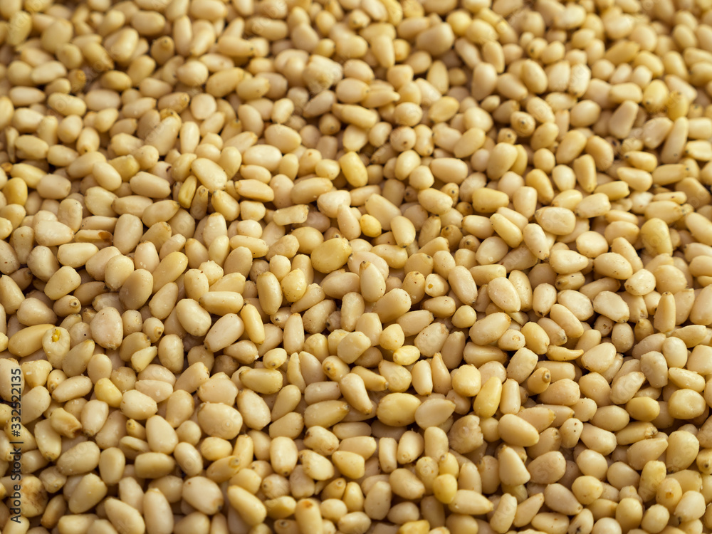 Pine nuts background. Unshelled cedar seeds, closeup Pine nuts background. Unshelled cedar seeds, closeup
