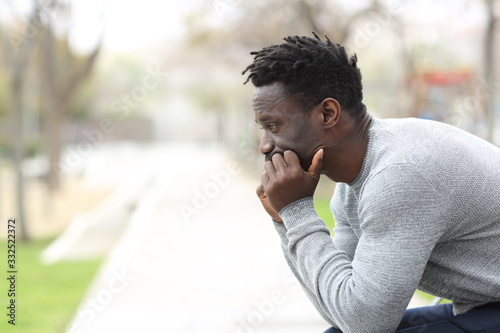 Fotografi Pensive serious black man looking away on a park