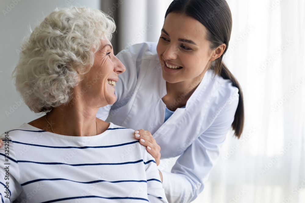 Caring young nurse support assist positive old lady patient at home or hospital, smiling female caregiver or doctor give help to optimistic mature senior grandmother, elderly healthcare concept Caring young nurse support assist positive old lady patient at home or hospital, smiling female caregiver or doctor give help to optimistic mature senior grandmother, elderly healthcare concept