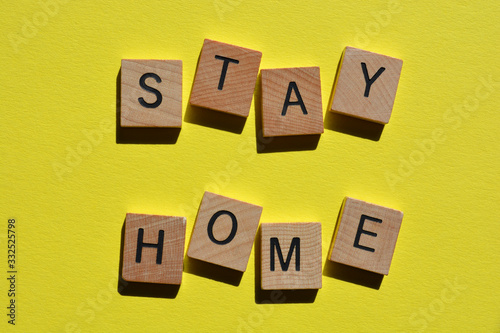 Stay Home, in wooden letters on yellow background