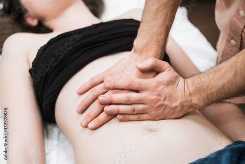 a man does a woman a massage of the abdomen, osteopathy 3