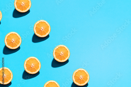 Minimal flat lay food texture. Summer abstract trendy fresh concept. Orange pattern on bright light blue background, copy space.