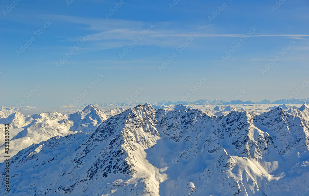 Panoramically view over Austrian Alps covered with snow on altitude higher than 3000 meters above the sea during sunny winter day.