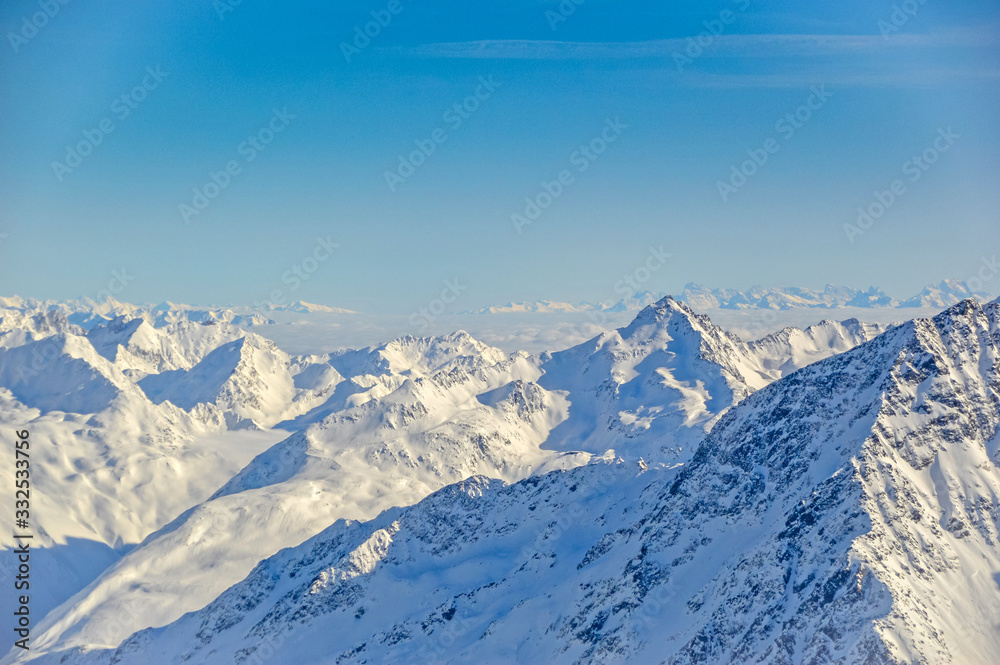 Panoramically view over Austrian Alps covered with snow on altitude higher than 3000 meters above the sea during sunny winter day.