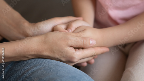 Crop close up of young mum holding little daughter hands having close tender intimate moment, mother and small girl child share secrets talking show love, care and affection, bonding, custody concept