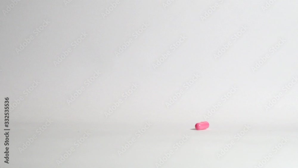 Pills and medicines falling in slow motion on white background. Cure and treatment against viruses and bacteria. Vitamin complex. Slow motion. Macro shot, detail. Pills and medicines falling in slow motion on white background. Cure and treatment against viruses and bacteria. Vitamin complex. Slow motion. Macro shot, detail.