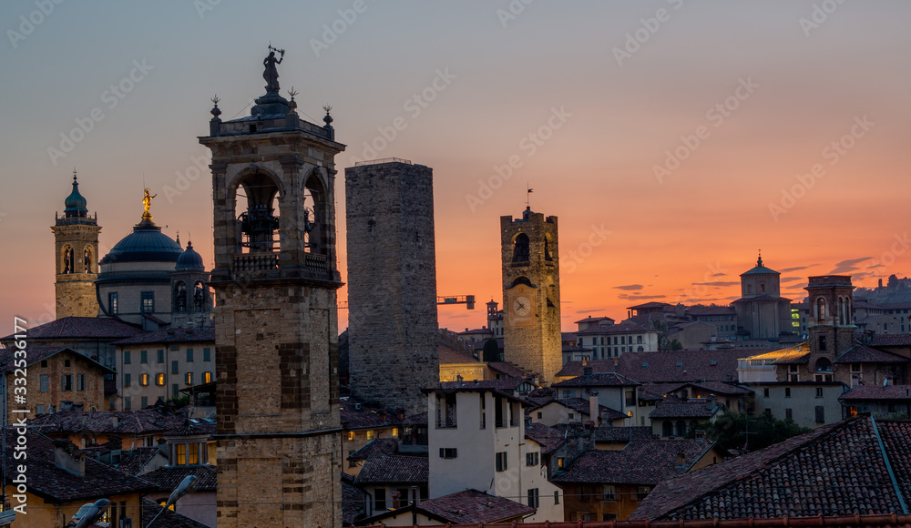 Bergamo at sunset in the old city with towers and bell tower,