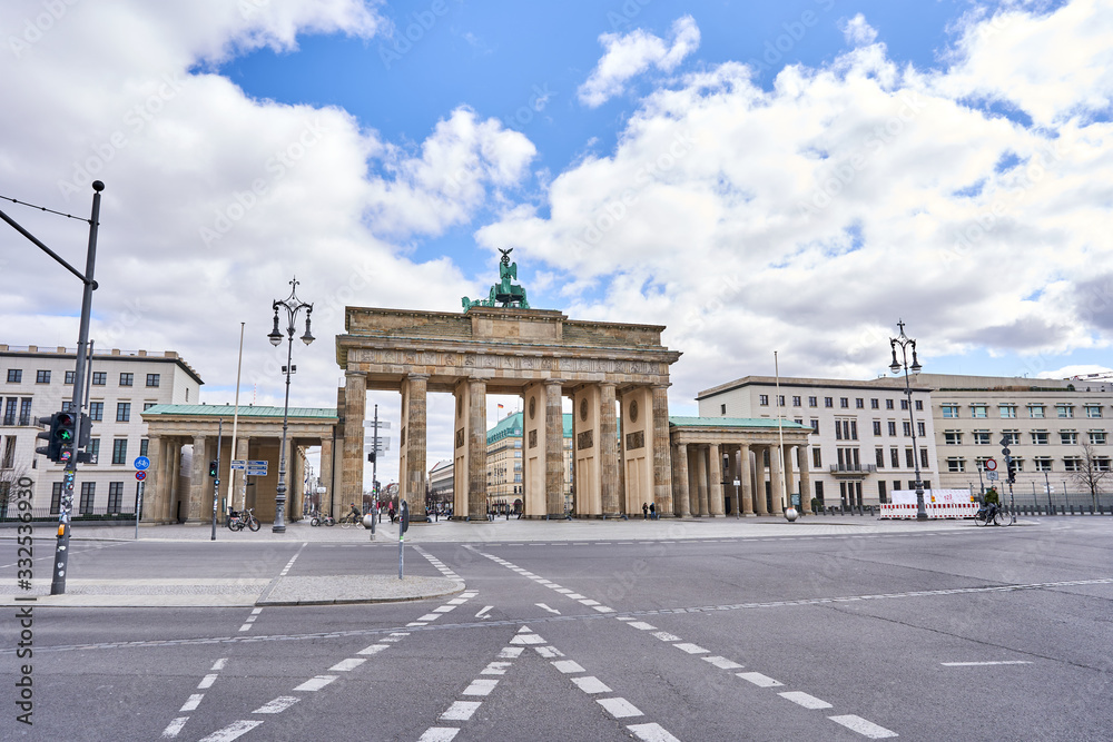 berlin, germany, view on the famous Brandenburg gate on the 10. May square in Berlin city, parisian square without tourists and visitors - deserted, blue sky, small clouds