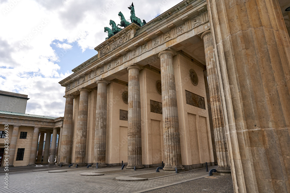 View on the famous Brandenburg gate on the Pariser square during the dusk in Berlin city, parisian square without tourists and visitors - deserted, sunset with blue sky and small clouds View on the famous Brandenburg gate on the Pariser square during the dusk in Berlin city, parisian square without tourists and visitors - deserted, sunset with blue sky and small clouds