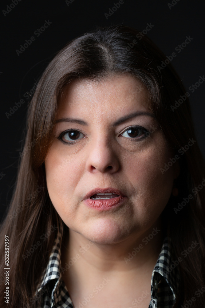 Lady head shot studio portrait. She is speaking and looking to the camera. Lady head shot studio portrait. She is speaking and looking to the camera.