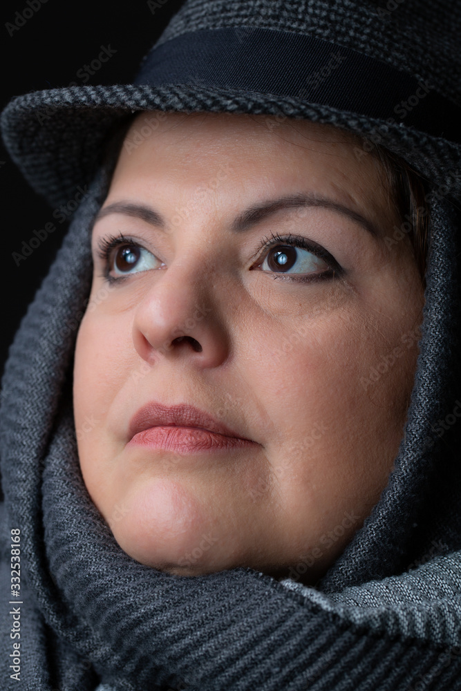 Lady head shot studio portrait. She is wearing a scarf and a hat. She is looking up. Lady head shot studio portrait. She is wearing a scarf and a hat. She is looking up.