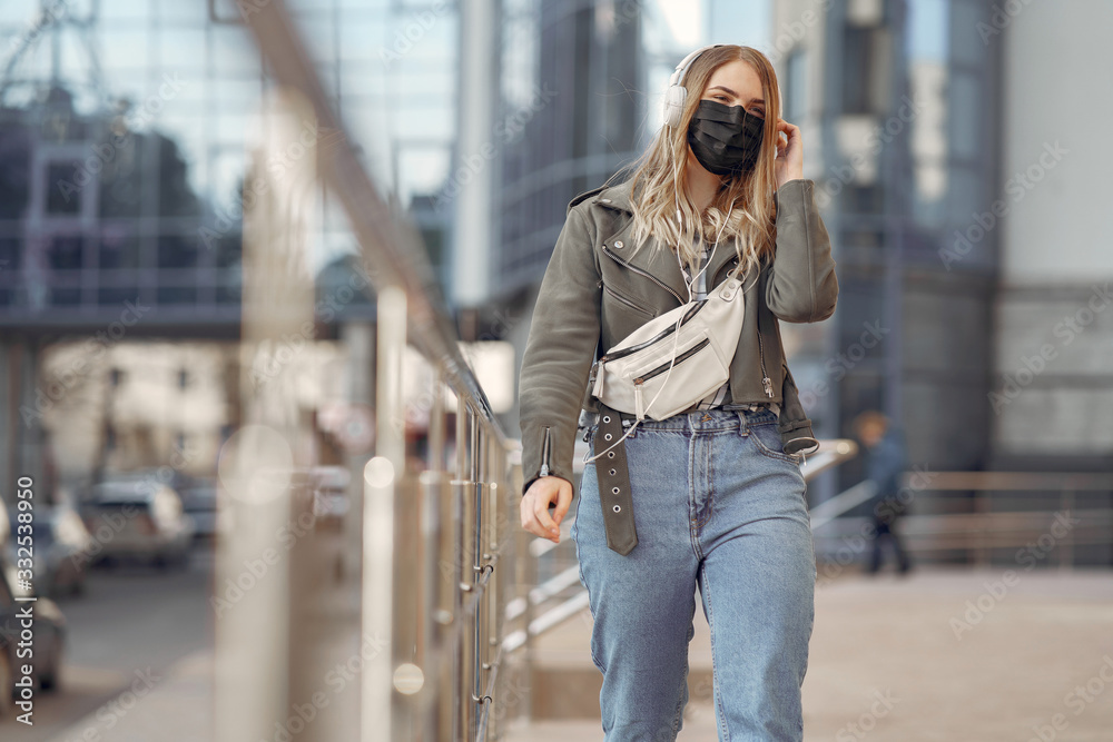 Fototapeta premium Woman in the city. Person in a mask. Coronavirus theme.