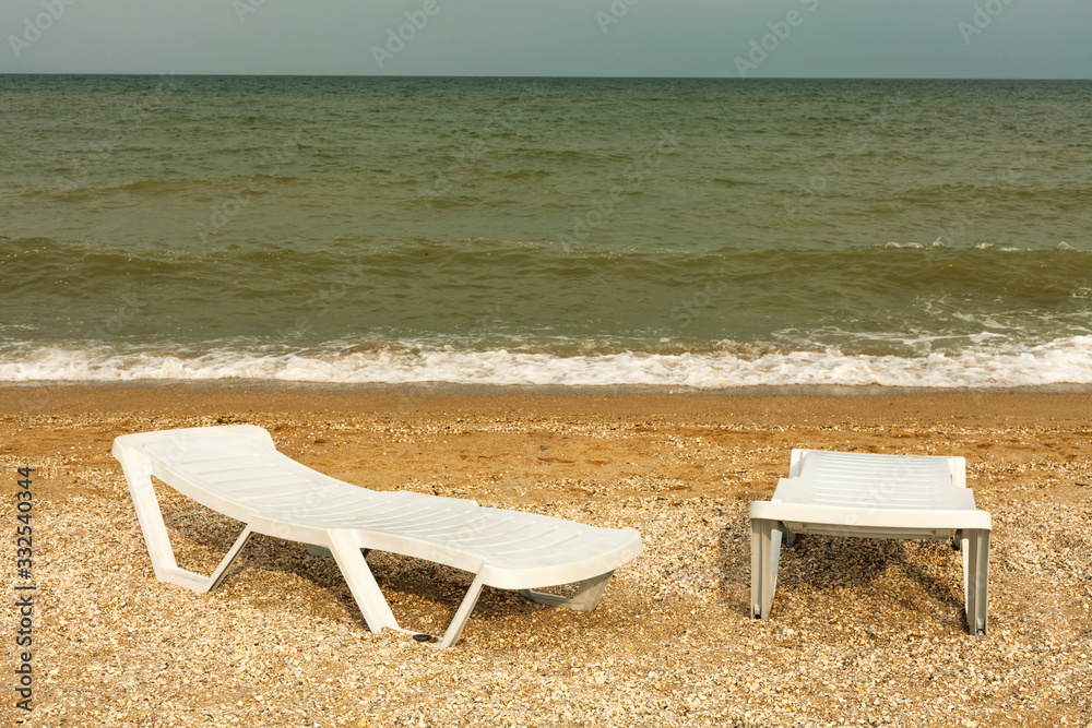 Plastic sunbeds on the golden beach. Sea view Plastic sunbeds on the golden beach. Sea view