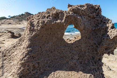 Rock with a wind hole in Pachena beach photo