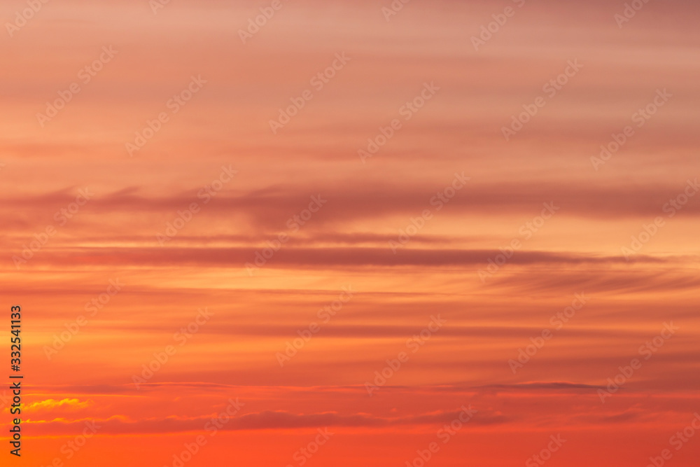 Bright soft sunrise, sunset orange yellow red sky with clouds background texture	