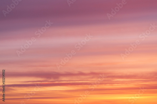 Dramatic bright soft sunrise, sunset pink orange red sky with clouds background texture