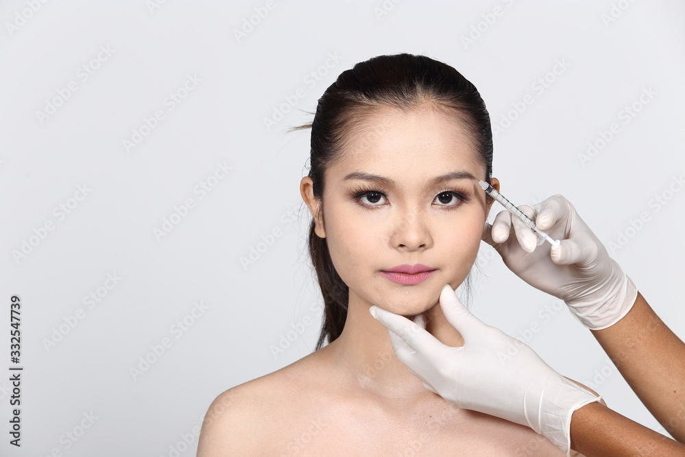Asian Beautiful Woman diagnose face skin structure and prepare to inject filler botox by syringe to lifting and treatment skincare for brighter smooth youthful, white background isolated Asian Beautiful Woman diagnose face skin structure and prepare to inject filler botox by syringe to lifting and treatment skincare for brighter smooth youthful, white background isolated