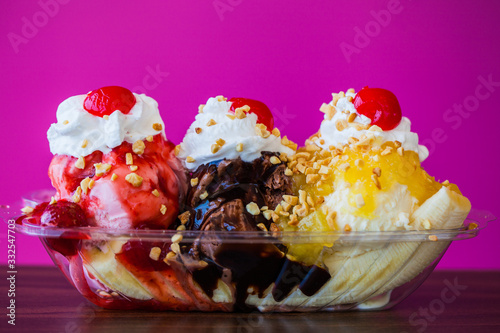 Принти на полотні Banana split ice cream with cherries on top against pink wall