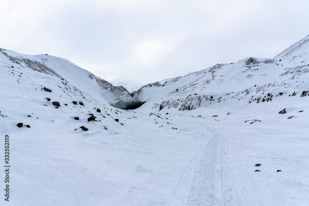 Hiking trail in northern Canada during winter season with an ice cave rocks in view. Winter times view in Yukon Territory. Hiking trail in northern Canada during winter season with an ice cave rocks in view. Winter times view in Yukon Territory.