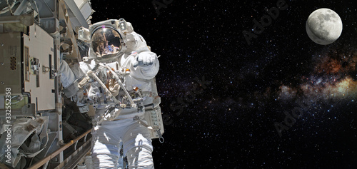 Astronaut on space mission with moon and earth on the background. Elements of this image furnished by NASA. photo