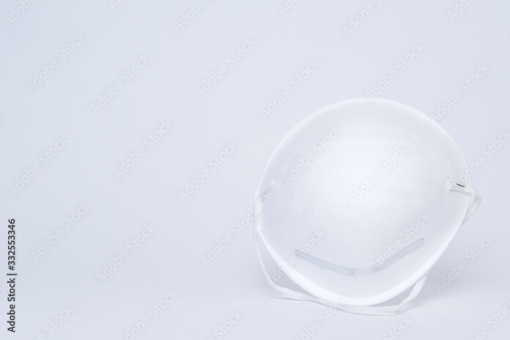 White single paper medical mask on light grey backdrop. Health protection, medicine concept. Front view, Copy space White single paper medical mask on light grey backdrop. Health protection, medicine concept. Front view, Copy space