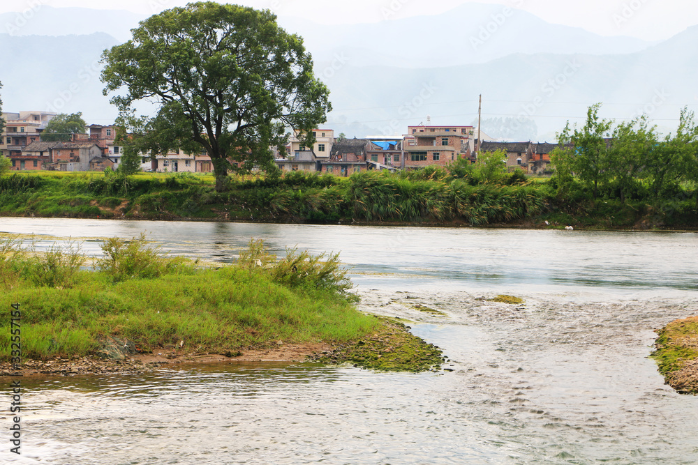 A village near a hill and a river A village near a hill and a river