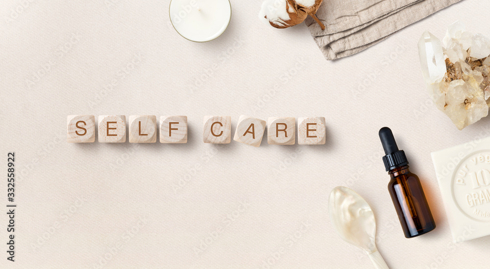 self care during quarantine / self-isolation / pandemic- conceptual image with dropper bottle, soap and wooden dices reading "self care", flat lay / top view - obrazy, fototapety, plakaty 
