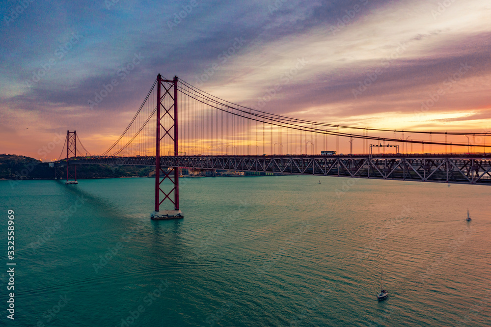 Lisbon, Portugal. Aerial view of the 25 de Abril Bridge (Ponte 25 de Abril, 25th of April Bridge) at sunset. It is often compared to the Golden Gate Bridge in San Francisco, US.