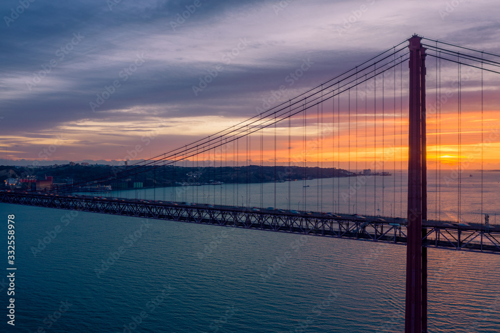 Lisbon, Portugal. Aerial view of the 25 de Abril Bridge (Ponte 25 de Abril, 25th of April Bridge) at sunset. It is often compared to the Golden Gate Bridge in San Francisco, US.