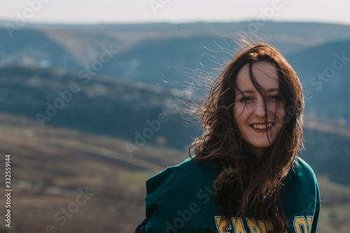 happy girl with developing hair in the wind having fun on a sunny day - portrait