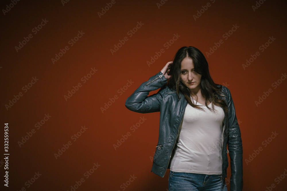 fashion girl posing in front of the red wall in the underground parking of the shopping center fashion girl posing in front of the red wall in the underground parking of the shopping center