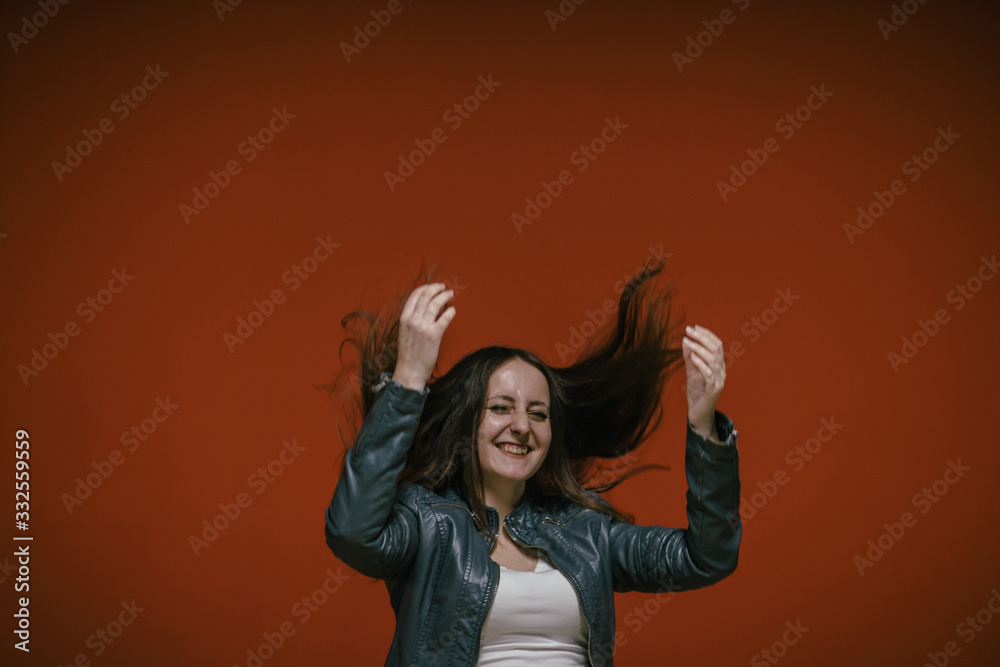 happy girl jumping on the background of the red wall in the underground parking of the shopping center happy girl jumping on the background of the red wall in the underground parking of the shopping center