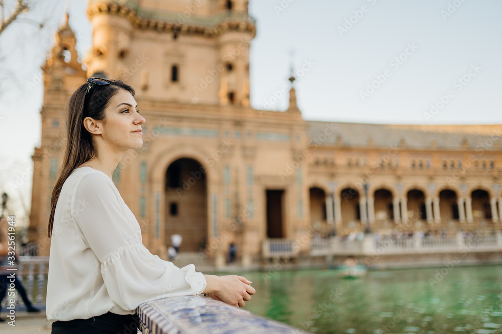 Young tourist woman looking over Plaza de Espana  in, Seville (Sevilla), Andalusia, Spain.Traveling to Spain.Sunset on Spain Square.Female  traveler visiting Spain,enjoying view,mindful walk.