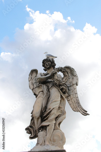 Angel Carrying the Crown of Thorns by Gian Lorenzo Bernini and a seagull stand on the top statue at Castel Sant Angelo  Rome  Italy